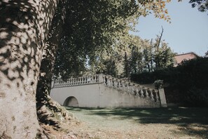 A stone bridge with a balustrade, surrounded by trees and grass. - Dwór Sieraków (Dobczyce)