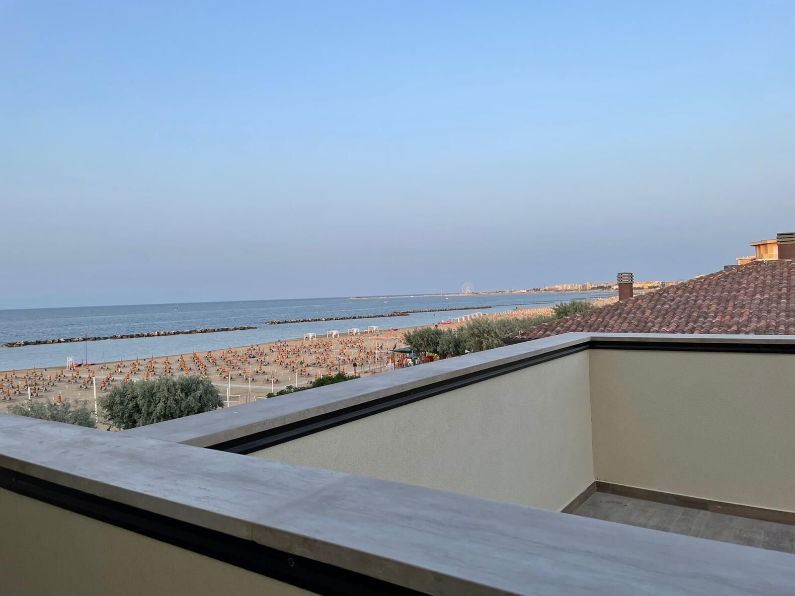 En balkon med udsigt over en strand og havet.