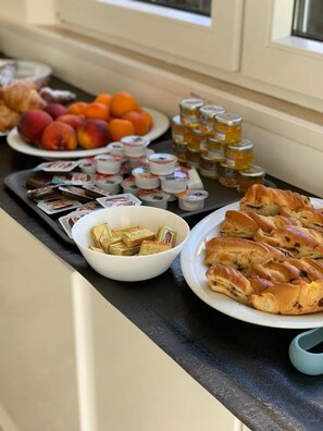 A buffet table with various food items including pastries, fruits, and condiments. - Hotel Costazzurra (Rimini)