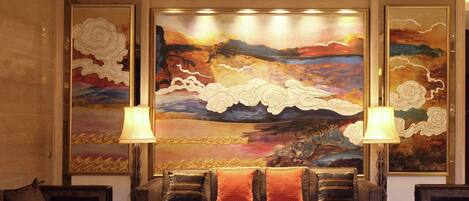 A modern living room with a large abstract painting, two sofas, and two floor lamps.