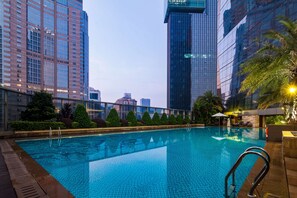 Una piscina con vistas a edificios altos al fondo.
