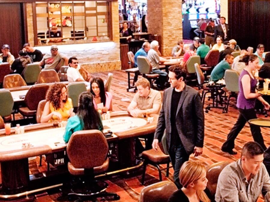 Un casino con múltiples mesas de blackjack y diferentes opciones de asientos.