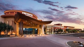 A modern hotel entrance with a curved facade, large windows, and a prominent sign reading "VEEQUIVA."