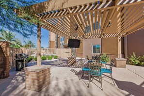 An outdoor patio with a pergola, seating area, and a barbecue grill. - Candlewood Suites Tucson by IHG (Tucson)