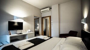 A hotel room with a bed, a TV, a desk, and a mirror. - Delta Hotel (Montevarchi)