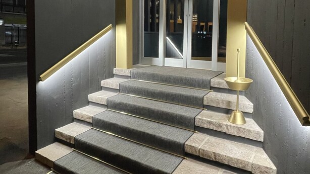 A staircase with a modern design, featuring a combination of stone steps and a carpeted landing. - Delta Hotel (Montevarchi)