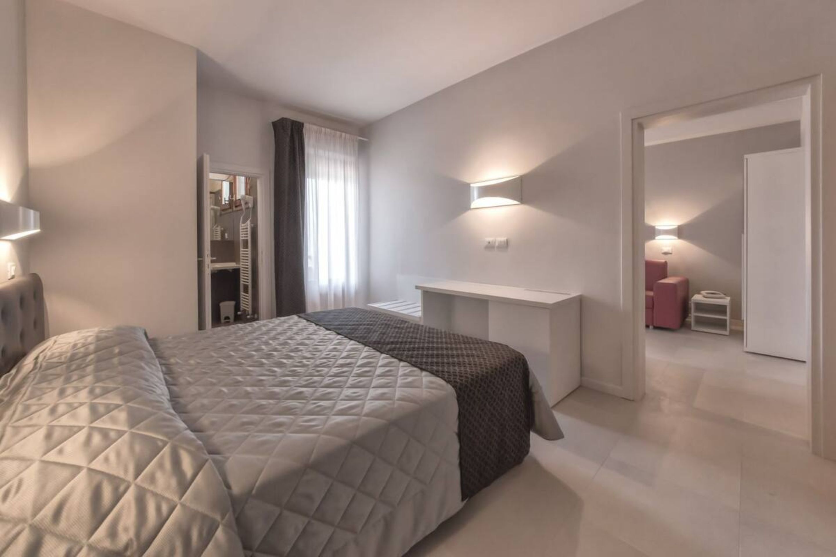 Un dormitorio moderno con una cama grande, un escritorio y un vestidor.