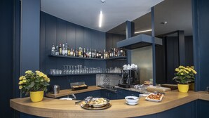 A modern bar area with a curved counter, a coffee machine, and a variety of bottles and glasses on shelves. - Delta Hotel (Montevarchi)