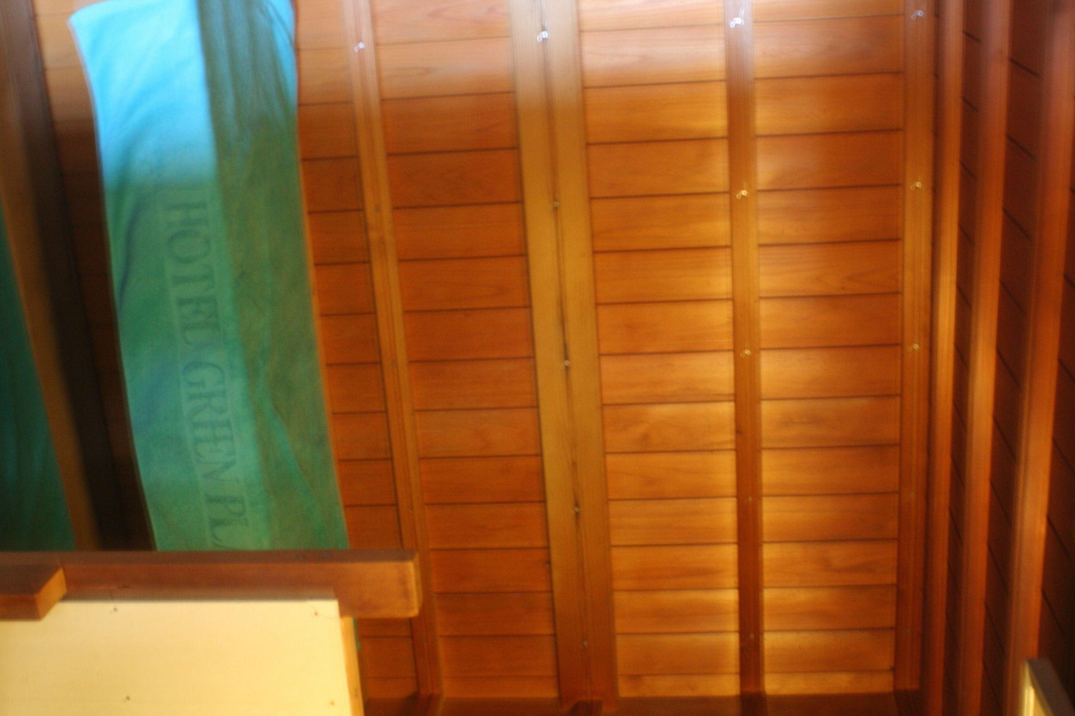 A wooden interior with a vertical wooden panel and a green object with text.