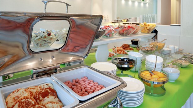 Buffet com diversos alimentos e toalha de mesa verde.