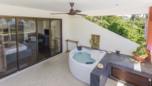 A modern bathroom with a bathtub, a shower, and a large window overlooking a lush garden. - Sallamai Resort (Koh Samui)