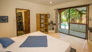 A bedroom with a bed, a wardrobe, a small table, and a view of the outdoors. - Sallamai Resort (Koh Samui)