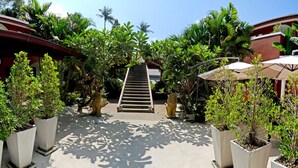 A staircase leading to a building surrounded by lush greenery and potted plants. - Sallamai Resort (Koh Samui)