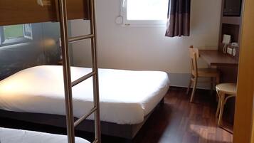 A compact room with bunk beds, a desk, and a chair.