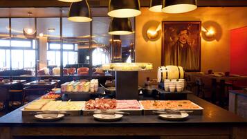 Un buffet proposant une variété de plats et un grand tableau accroché au mur.