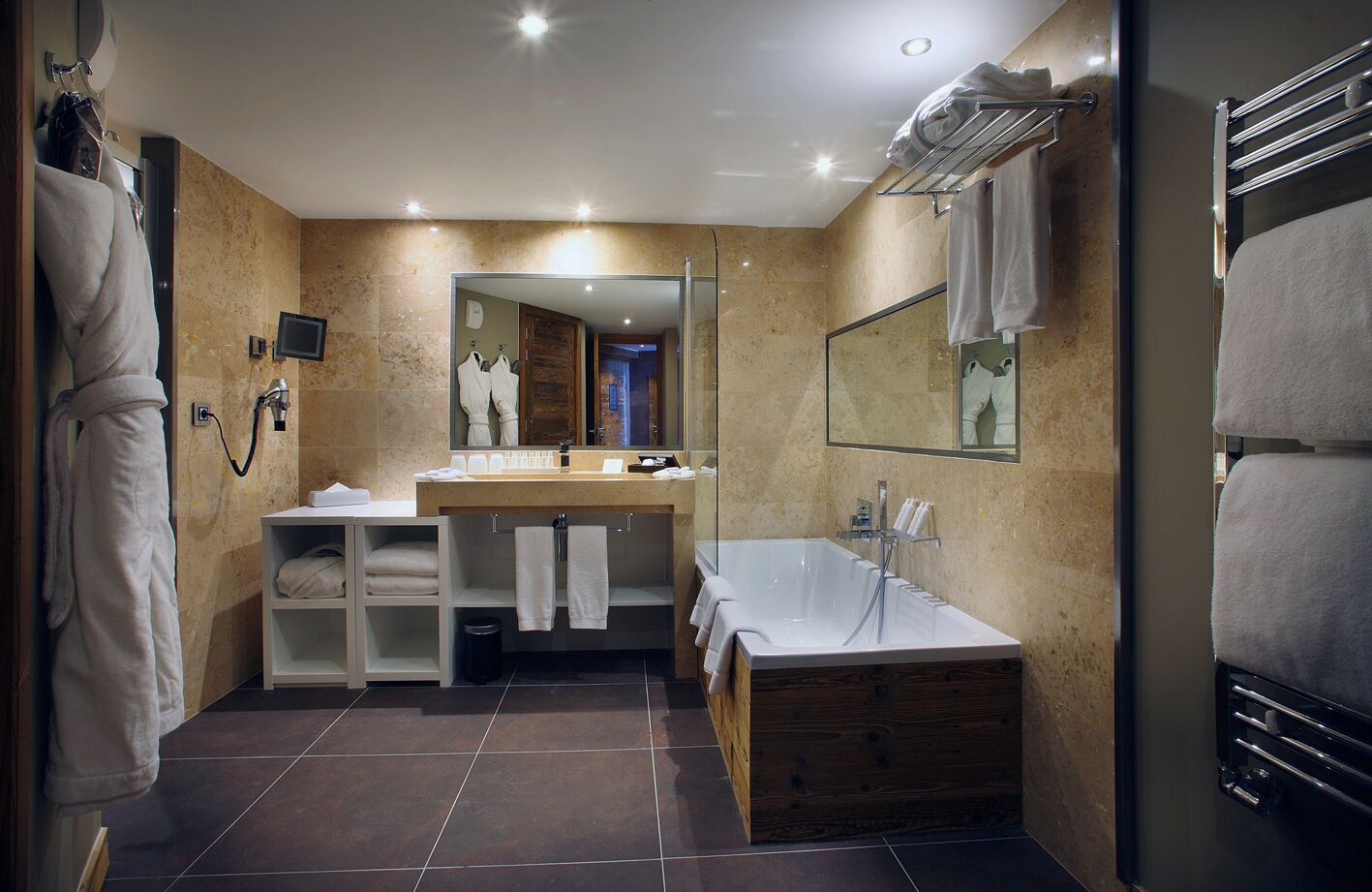 A modern bathroom with a bathtub, a vanity, and a large mirror.