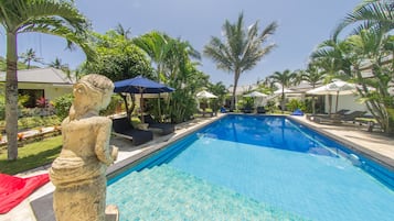 Una piscina al aire libre, sombrillas, tumbonas