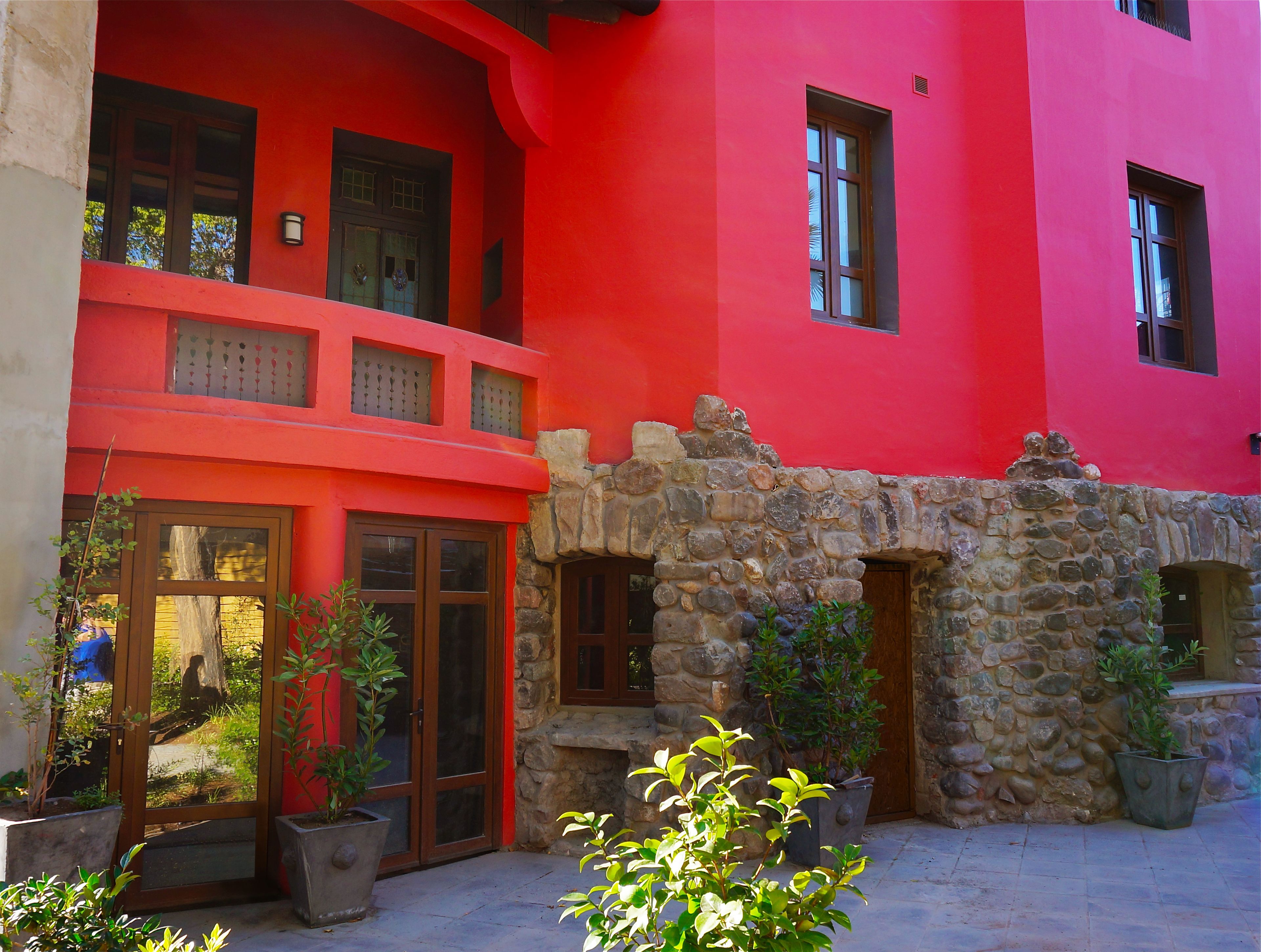 A red building with stone walls and multiple windows.