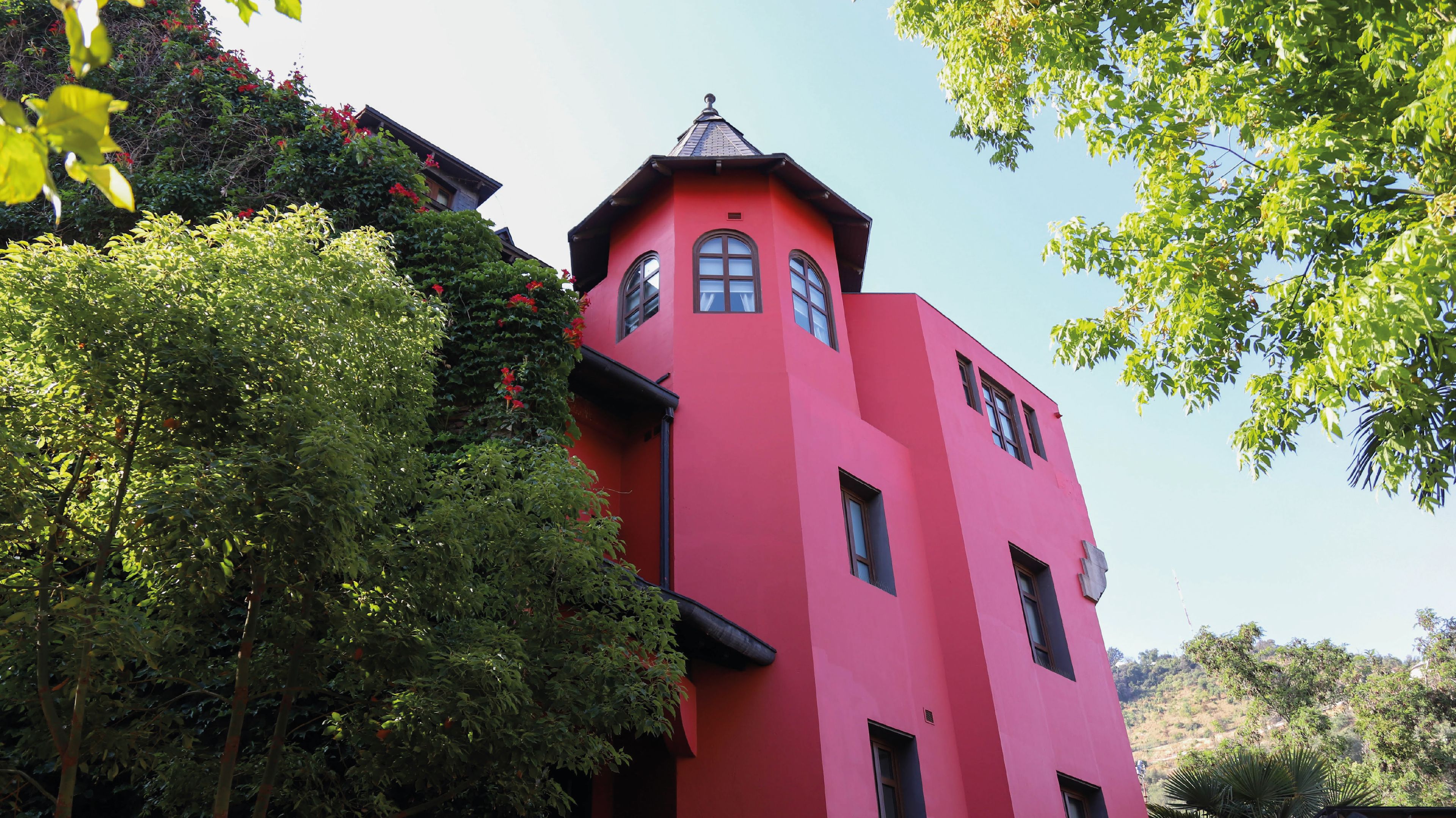 A red building with multiple windows and a tower-like structure.