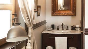 A bathroom with a vanity, a mirror, a towel rack, and a lamp.