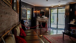 Een hotel lobby met een open haard, een rode lintbarrière en een bord dat een kerstdiner evenement aangeeft.