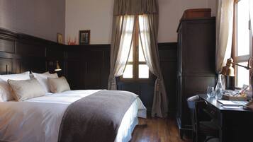 A bedroom with a bed, a desk, and a wardrobe.
