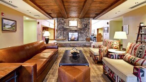A spacious lobby with a stone fireplace, leather sofas, and patterned armchairs.