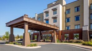 A modern hotel with a covered entrance, multiple floors, and a sign reading "Homewood."