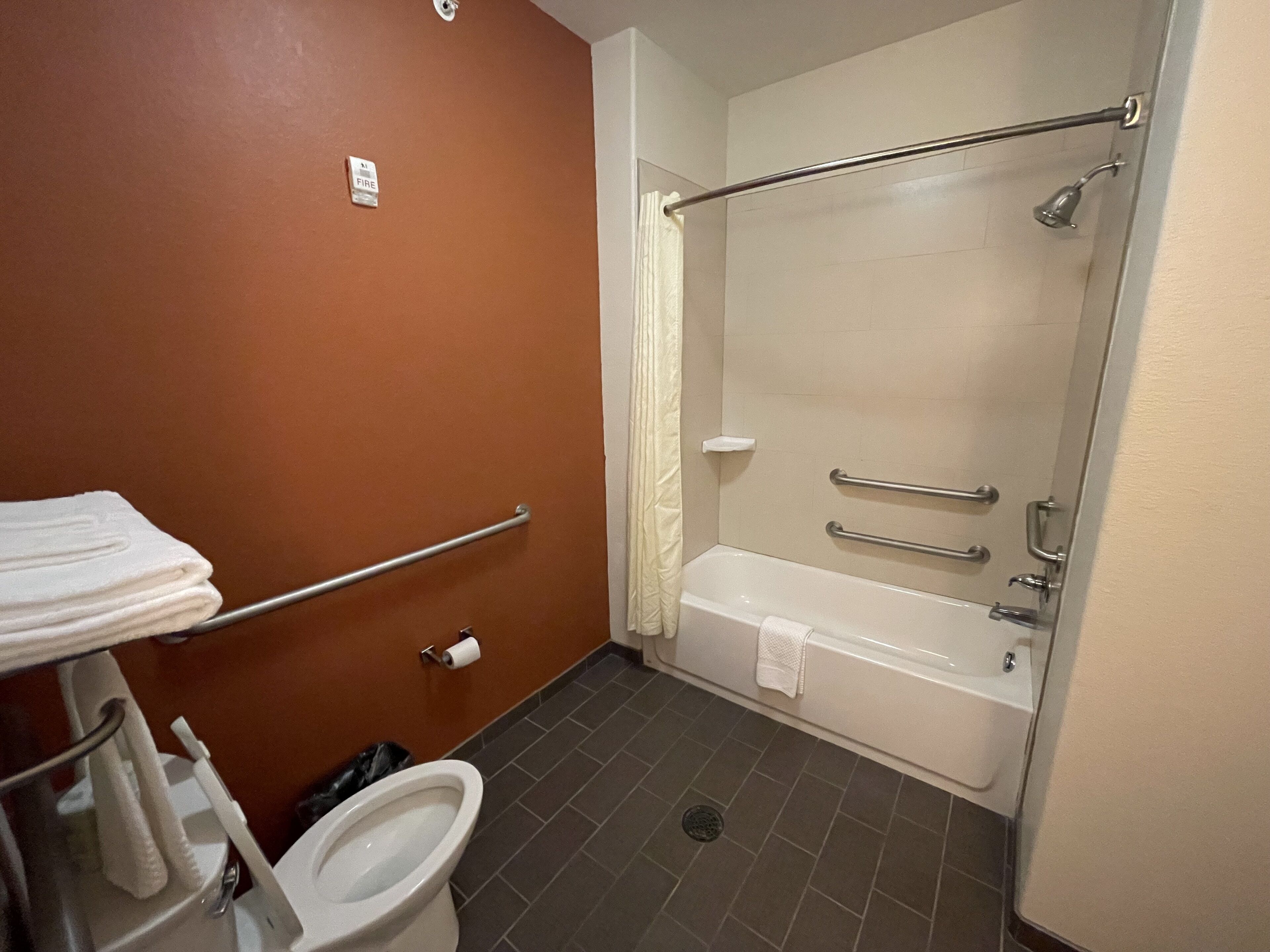 A bathroom with a toilet, a sink, a shower, and a towel rack.
