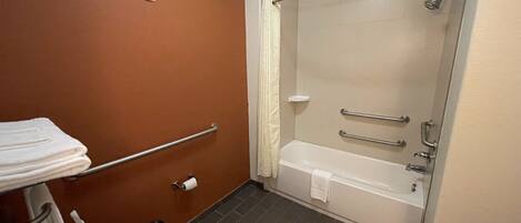 A bathroom with a toilet, a sink, a shower, and a towel rack.