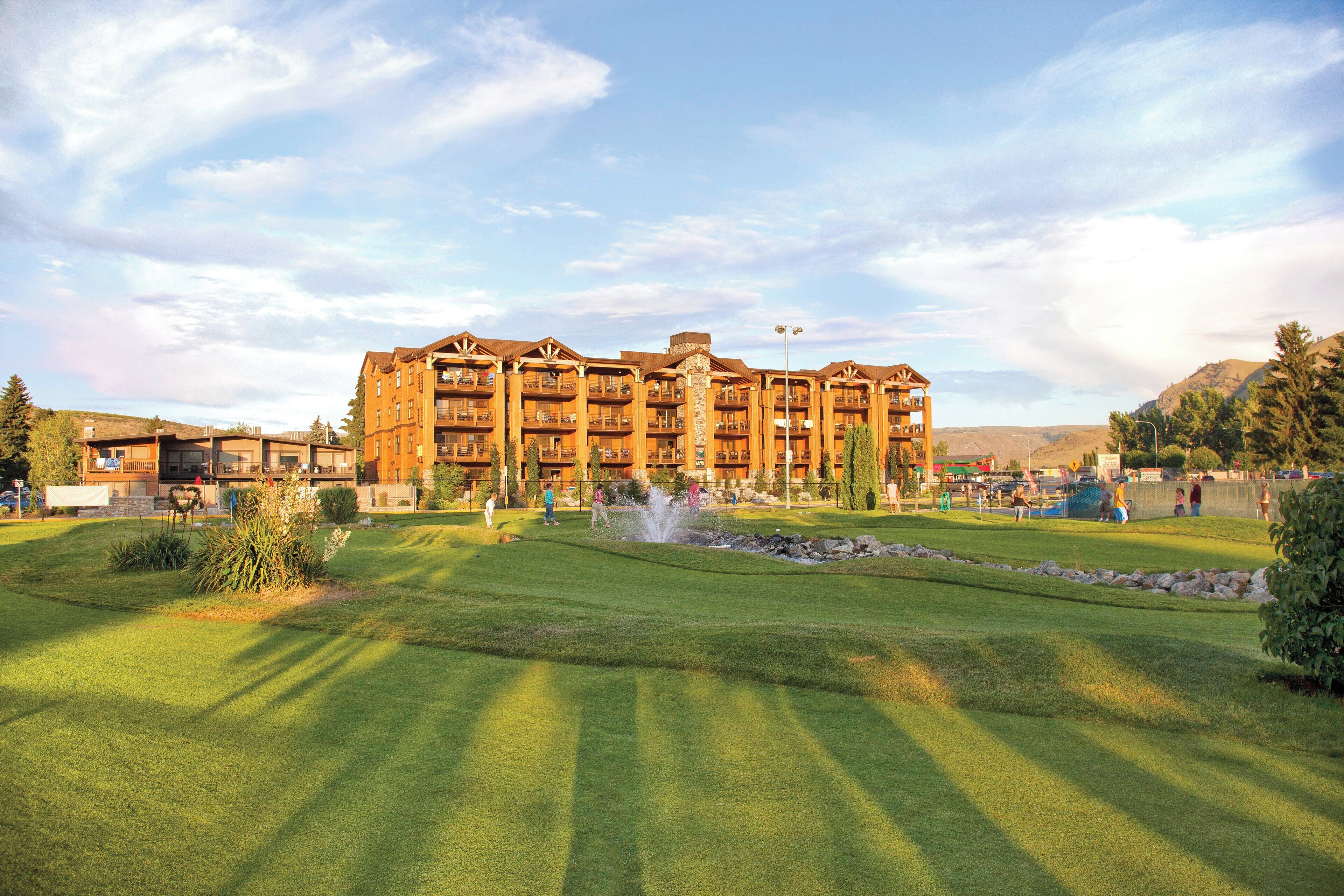 A multi-story hotel with a central courtyard, outdoor seating area, and a fountain.