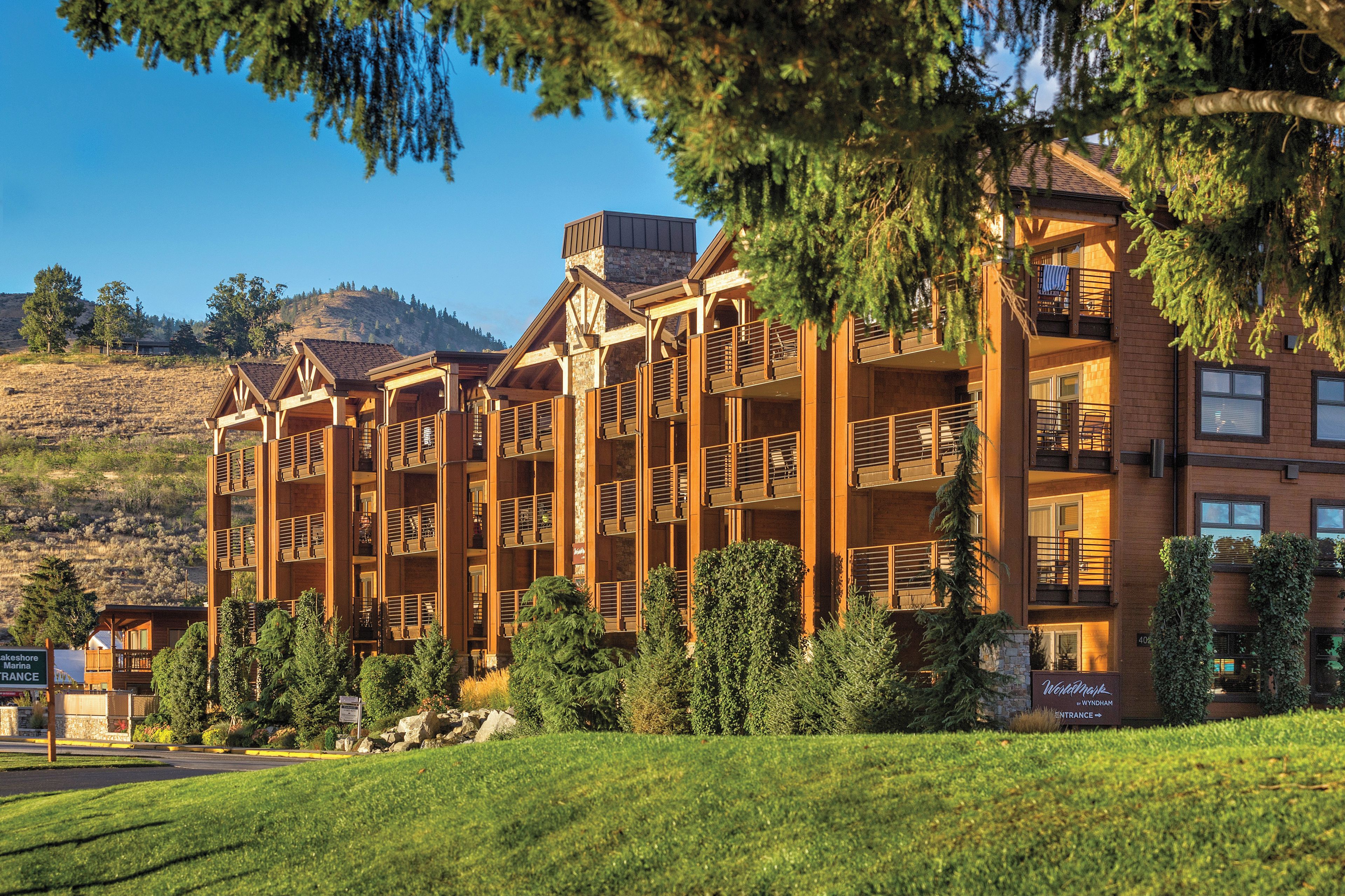 A multi-story lodge with a wooden exterior, balconies, and a sign indicating it is a ski resort.