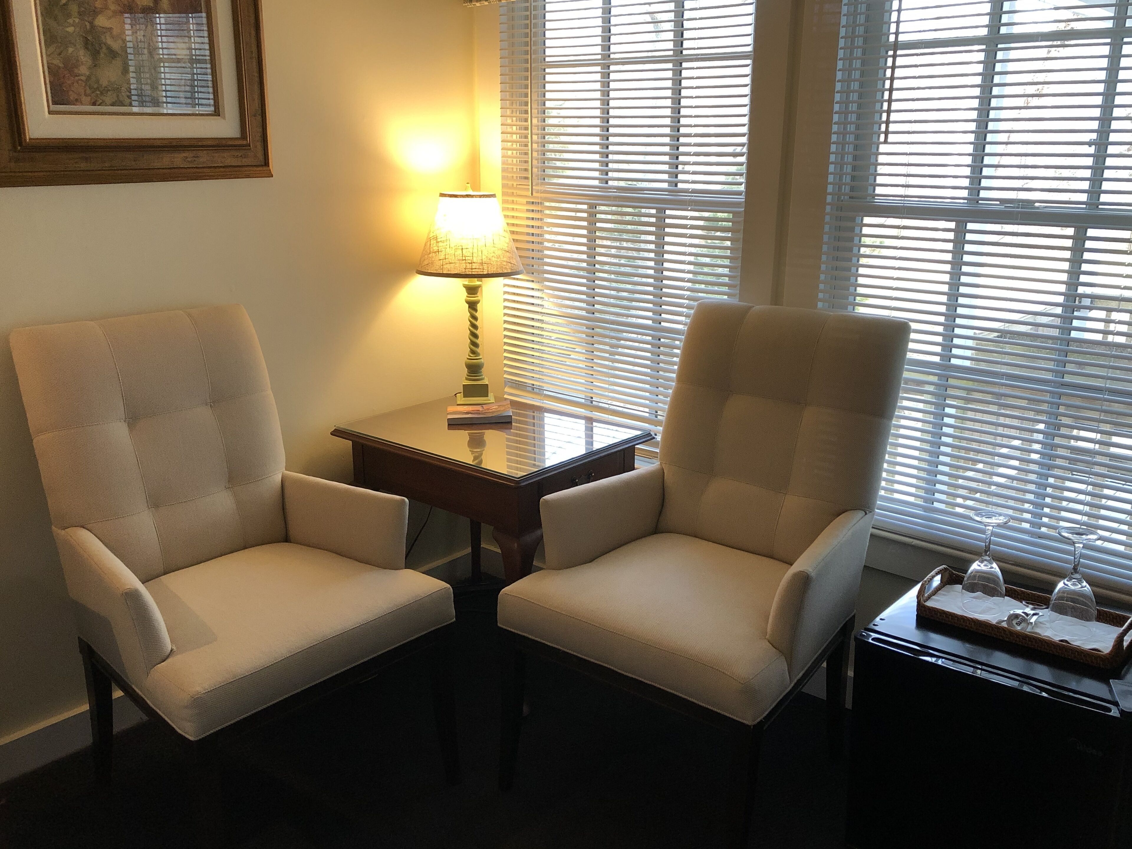 Deux fauteuils placés face à face, avec une petite table et une lampe entre eux.