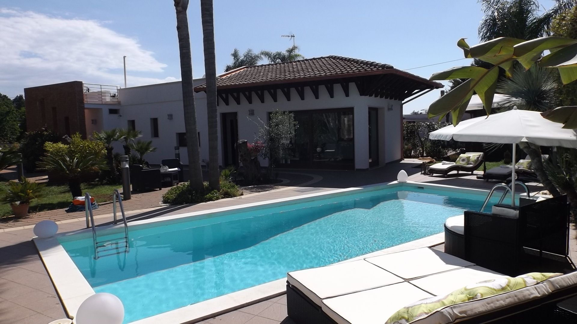Una piscina al aire libre de temporada, sillones reclinables de piscina