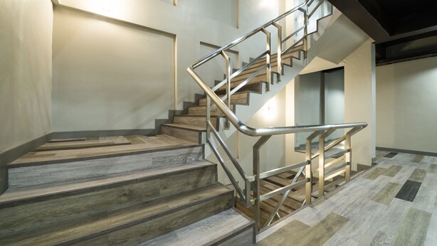A staircase with wooden steps and metal railings, leading to an upper floor. - Alfresco Phuket Hotel (Patong)