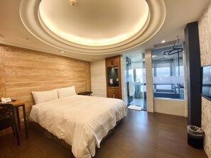 A modern hotel room with a large bed, wooden wall paneling, a small bedside table with a phone, and a view of a cityscape through a glass door. - Burgary Hotel (Taipei)
