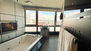 A modern bathroom with a large bathtub, a sink, and a towel rack. - Burgary Hotel (Taipei)