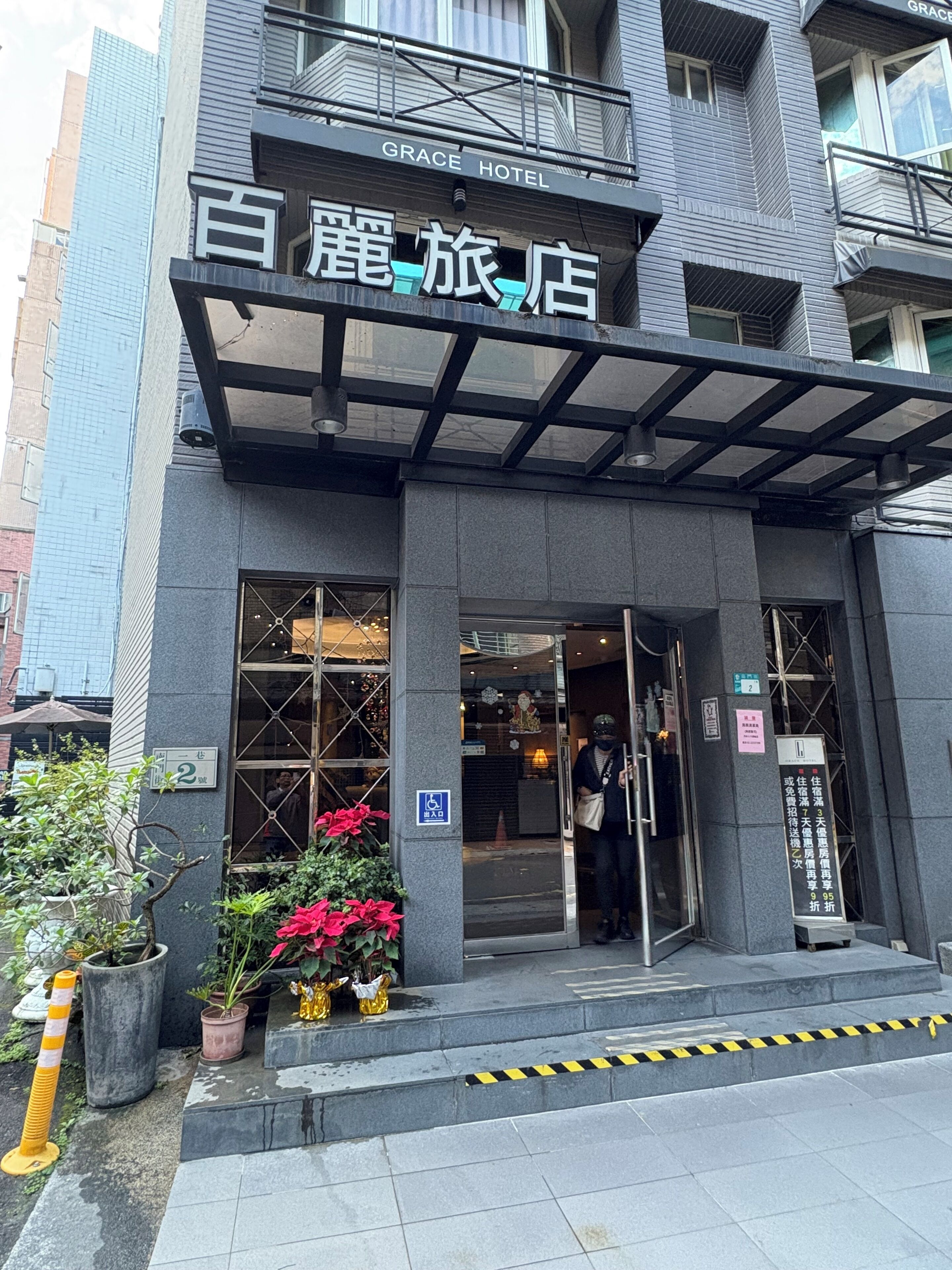 A hotel entrance with a covered entrance, a sign for the Grace Hotel, and a wheelchair accessibility sign.