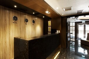 Un mostrador de recepción con relojes que marcan la hora en Nueva York, Tokio y Londres.