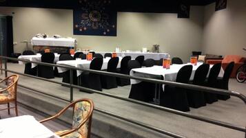 A conference room with multiple tables, chairs, and a bicycle in the background.