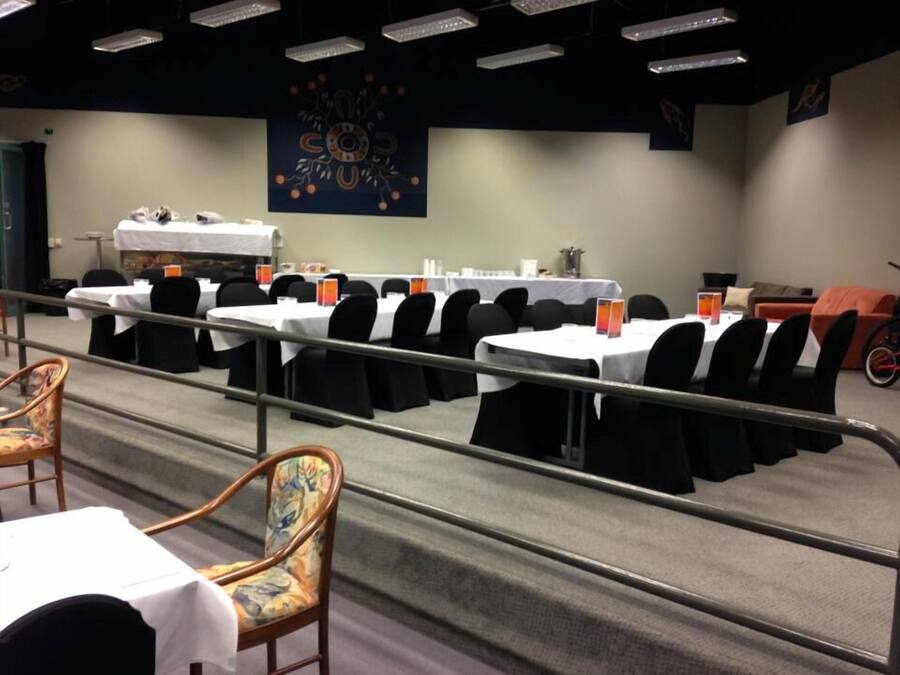A conference room with multiple tables, chairs, and a bicycle in the background.