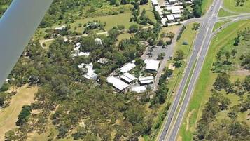 An aerial view of a residential area with houses, a highway, and a road intersection.