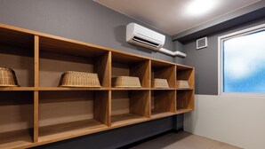 A room with wooden shelves and wicker baskets, an air conditioning unit, and a window with a view. - Select Inn Fujisan Gotemba (Gotemba)