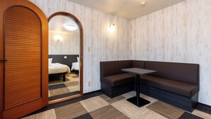 A modern hotel room with a wooden door, a sofa, a small table, and a checkered floor. - Select Inn Fujisan Gotemba (Gotemba)