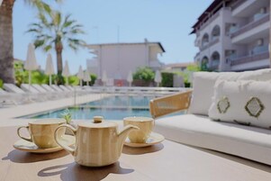 Una piscina al aire libre de temporada, sombrillas