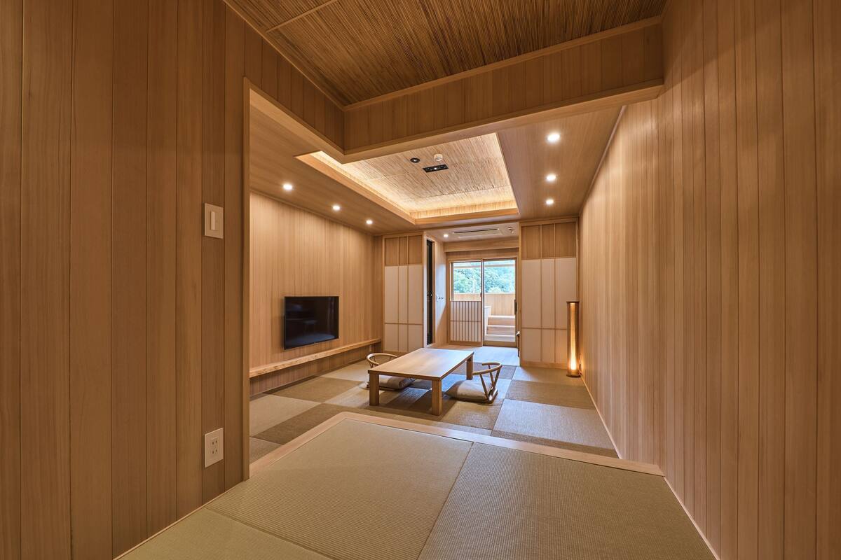 A traditional Japanese-style room with tatami flooring, a low table, and sliding doors.