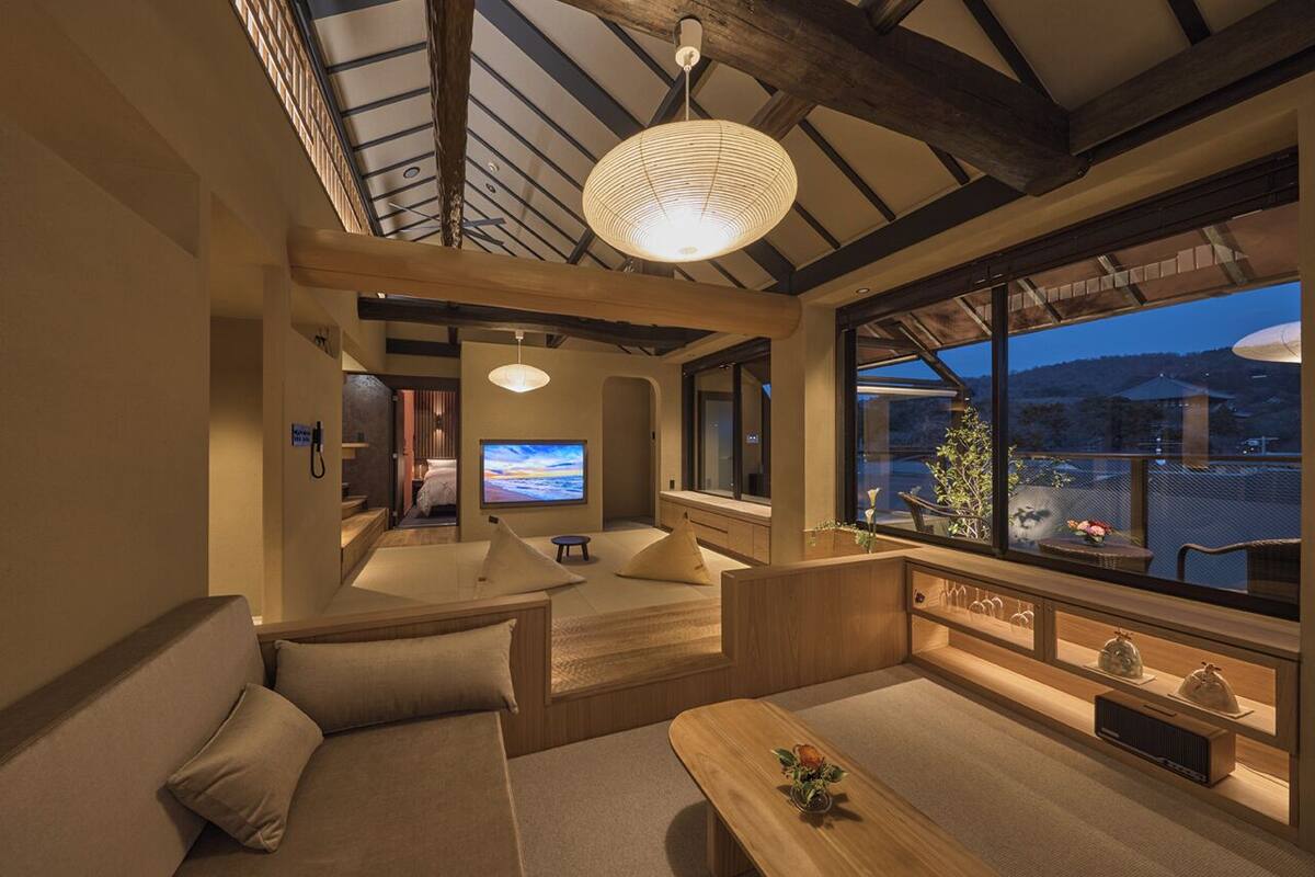 A modern interior with a wooden ceiling, a sofa, a wooden table, and a television.