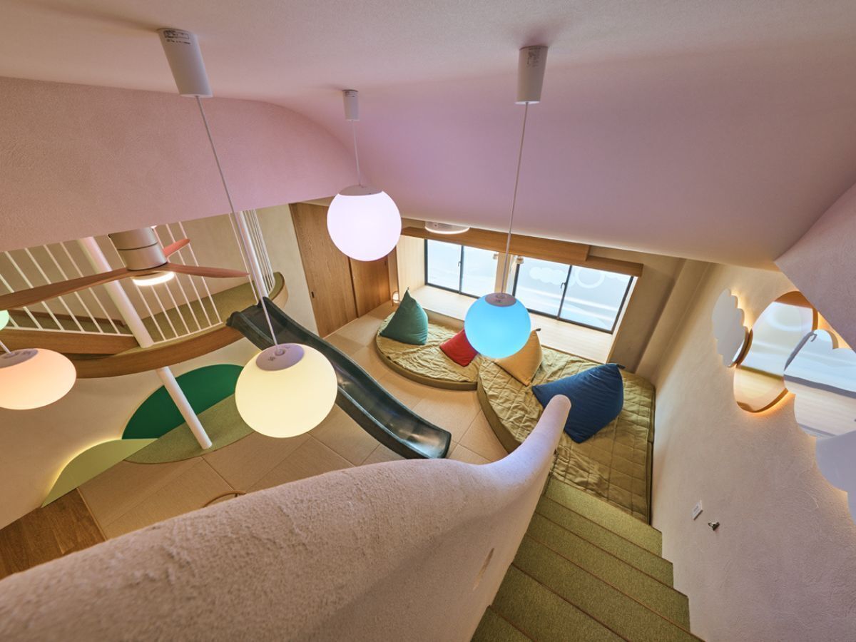 A modern interior with a spiral staircase, a slide, and a cozy seating area with cushions.