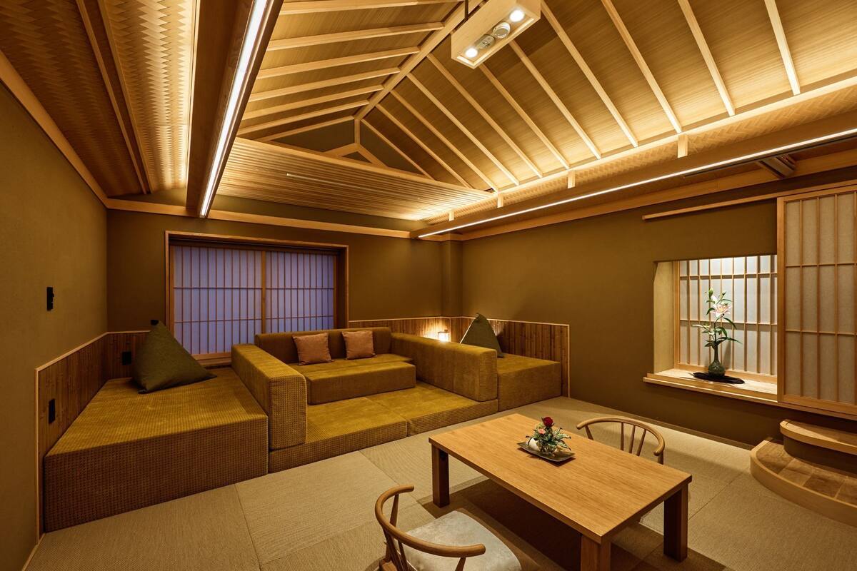 A traditional Japanese-style room with tatami flooring, low wooden furniture, and a sliding shoji screen door.