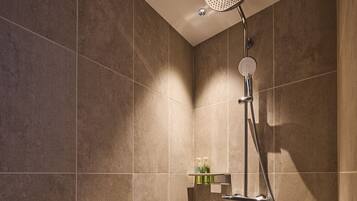 A modern shower with a handheld showerhead and a wall-mounted control.